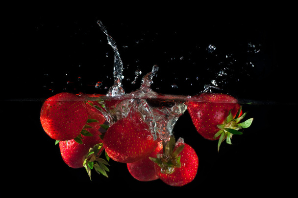 Strawberries splashing into water  - Fotoğraf, Görsel