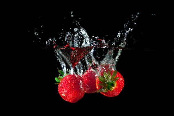 Strawberries splashing into water  - 写真・画像