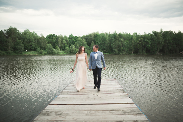 Wedding couple, bride, groom walking and posing on pier - Valokuva, kuva