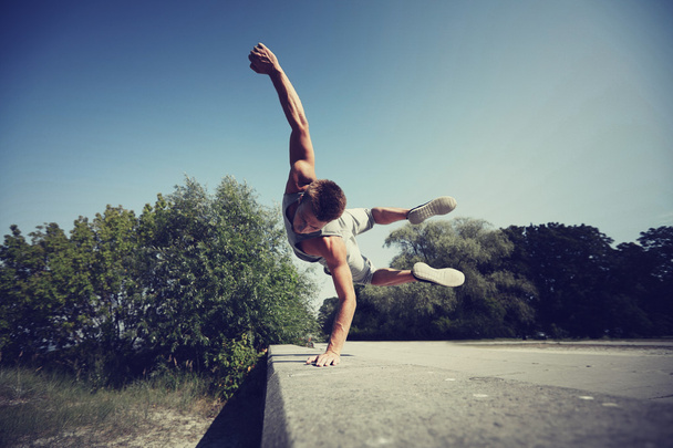 sporty young man jumping in summer park - Fotó, kép