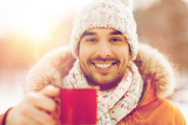 happy man with tea cup outdoors in winter - Foto, Imagen