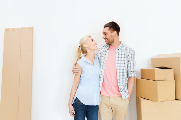 couple with cardboard boxes moving to new home - Foto, Imagen