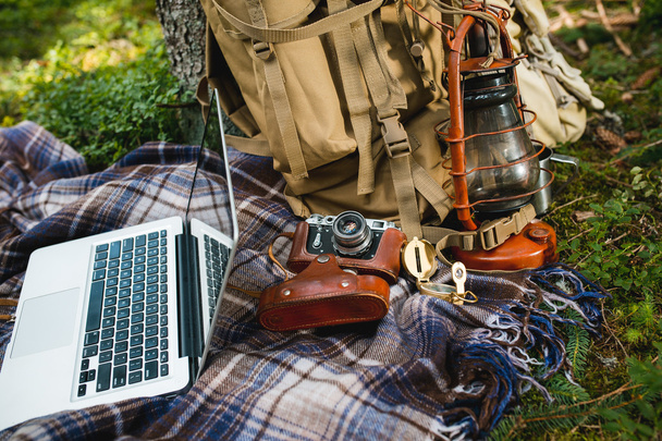 Активный туризм кемпинг оборудование ретро фотокамера и рюкзак на заднем плане открытый лес природа
 - Фото, изображение