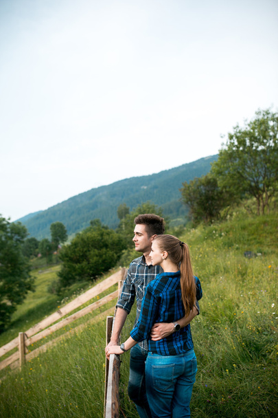 Guy and girl lovers tourists relax and admire beautiful mountain scenery - Fotoğraf, Görsel