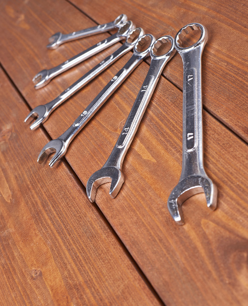 Set of wrenchs chrome metal spanner instruments on wooden surface - Фото, зображення