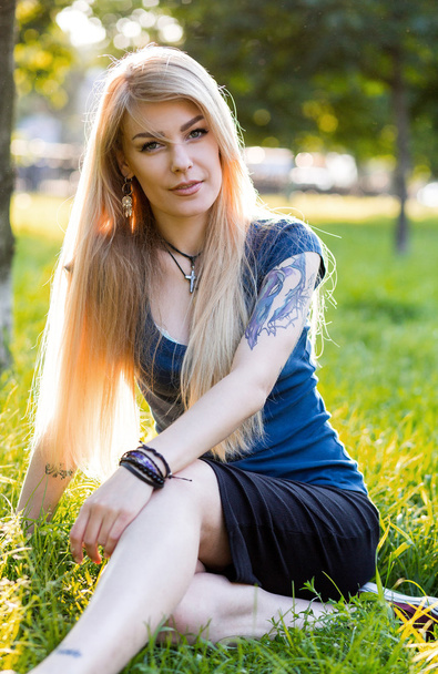 Portret van een mooie jonge blondjes met lange haren en schattige glimlach buitenshuis - Foto, afbeelding