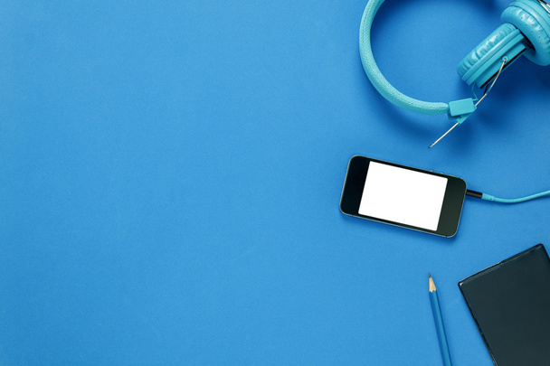 Topo papel nota vista, fones de ouvido, smartphone, lápis, no fundo azul
 - Foto, Imagem