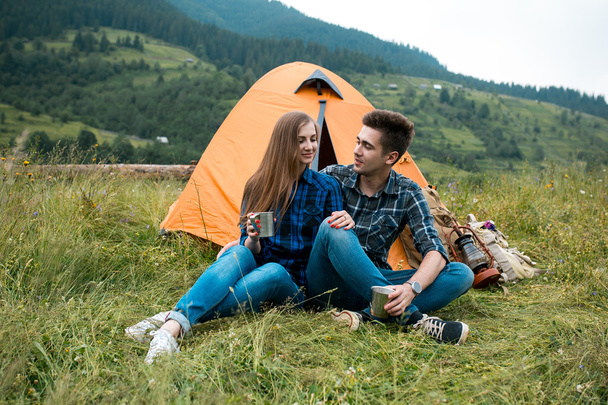 Jongen en meisje liefhebbers toeristen ontspannen en genieten van prachtige berglandschap - Foto, afbeelding