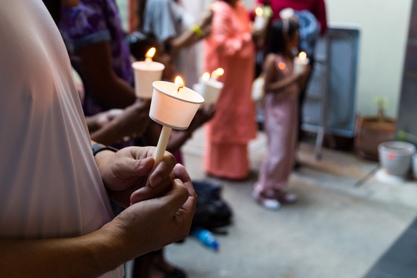Primer plano de personas celebrando vigilia de velas en la oscuridad buscando esperanza
 - Foto, Imagen