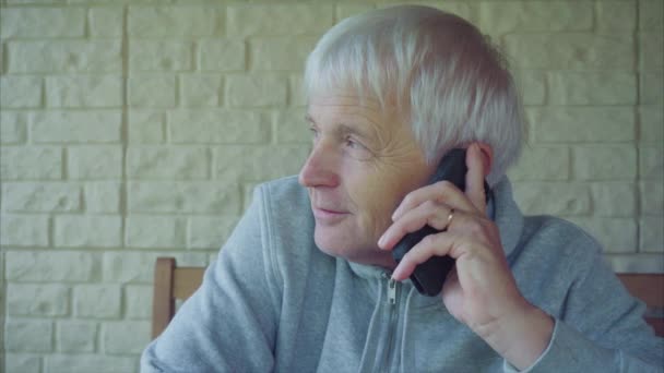 Senior Kaukasische man met grijs haar praten op mobiele telefoon - Video
