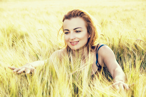 Прекрасна жінка в пшеничних цицьках на заході сонця, ретро фотофільтр
 - Фото, зображення
