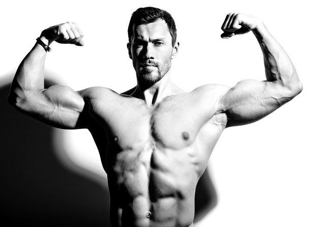 Portrait of strong healthy handsome Athletic Man Fitness Model posing near white wall - Φωτογραφία, εικόνα