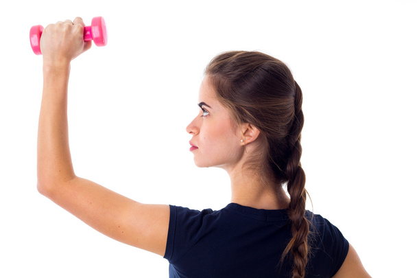 Woman holding a pink dumbbell - Foto, Imagen