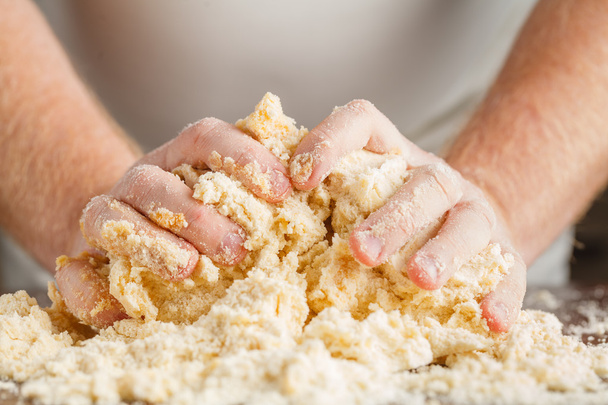 person kneading dough on wooden table - Fotoğraf, Görsel