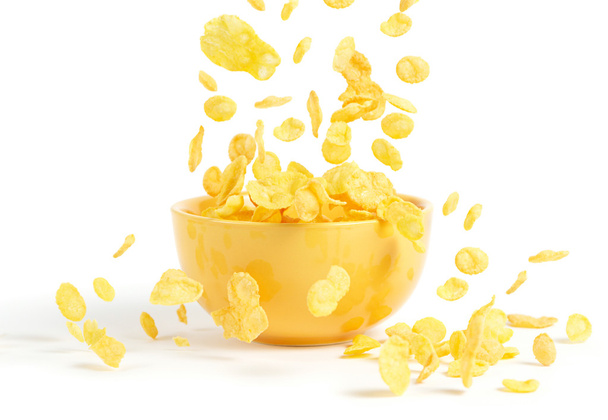 Golden cornflakes falling into the breakfast bowl - Photo, Image