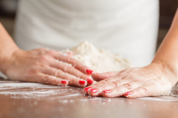 виготовлення сирого тіста руками жінки на столі
 - Фото, зображення
