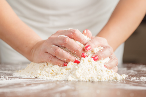 Hand of woman kneading dough for yeast cake on wooden table, pre - Foto, immagini
