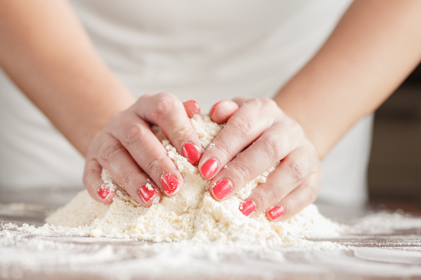 Hand of woman kneading dough for yeast cake on wooden table, pre - Foto, Bild