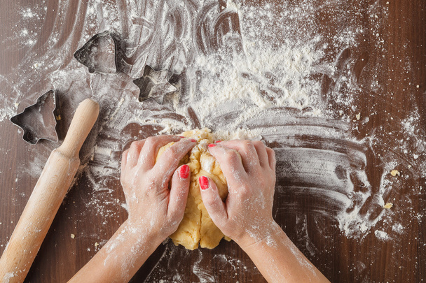 woman's hands kneading dough on wooden table - Foto, Imagem