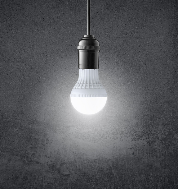 Lâmpada LED brilhante na parede grunge
 - Foto, Imagem