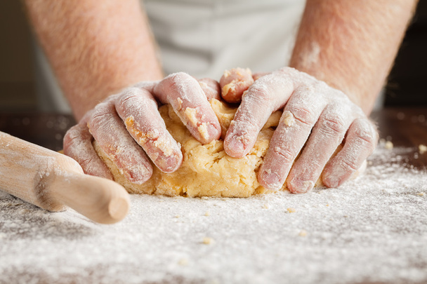 Making dough by men hands on wooden table background - Foto, Imagen