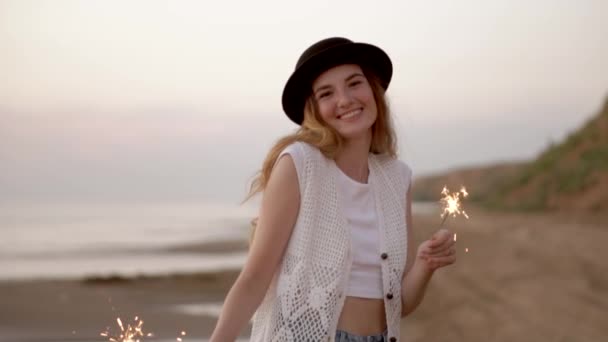 Adolescente belle fille avec des étincelles sur la plage au coucher du soleil
 - Séquence, vidéo