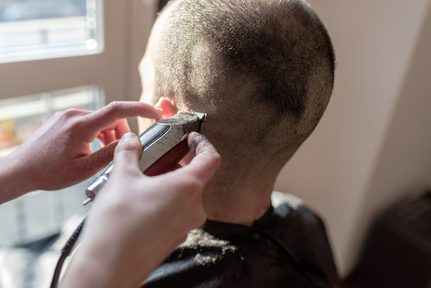 Friseur schneidet mit Rasiermesser die Haare - Foto, Bild
