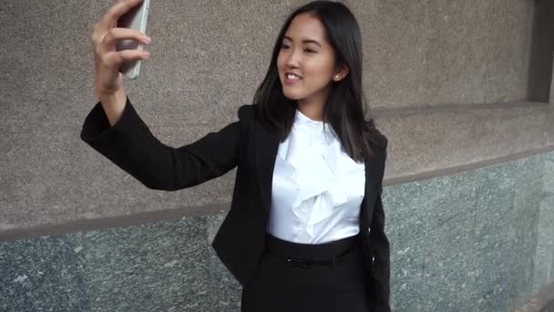 Jeune belle femme d'affaires femelle fille portrait tenir utiliser téléphone prendre faire Selfie moderne sur fond immeuble de bureaux en plein air
 - Séquence, vidéo