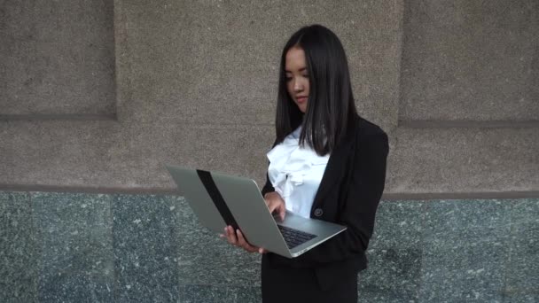 Fiatal gyönyörű üzleti nő női lány portré tartani használ sajtó Laptop billentyűzet háttér irodaház szabadtéri - Felvétel, videó