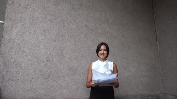 Giovane bella donna d'affari femmina ragazza ritratto tenere buttare documenti su sfondo ufficio edificio all'aperto
 - Filmati, video
