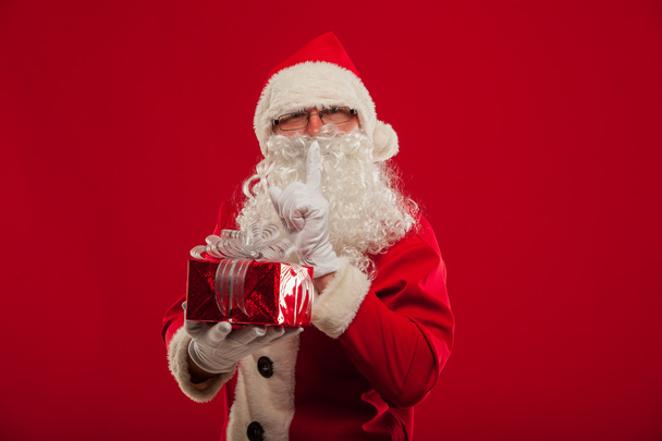 Photo of kind Santa Claus giving xmas present and looking at cam - Φωτογραφία, εικόνα
