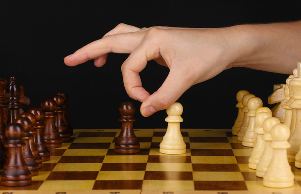 Σκακιέρα με τα κομμάτια σκακιού που απομονώνονται σε μαύρο - Φωτογραφία, εικόνα