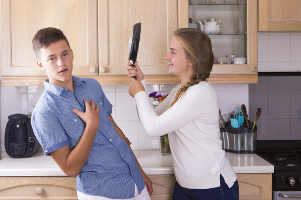 Los hermanos adolescentes que tienen lucha en la cocina
 - Foto, Imagen