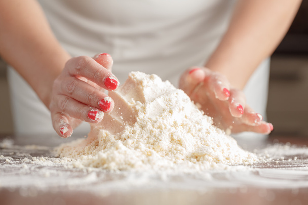 woman's hands kneading dough on wooden table - Foto, immagini