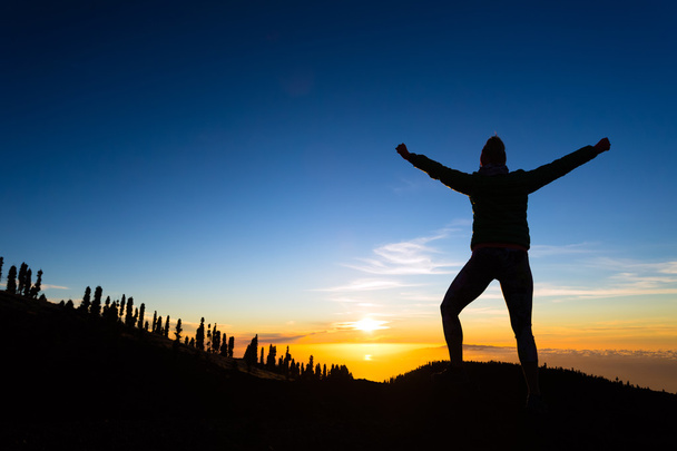 Mujer excursionista con los brazos extendidos disfrutar de las montañas
 - Foto, imagen