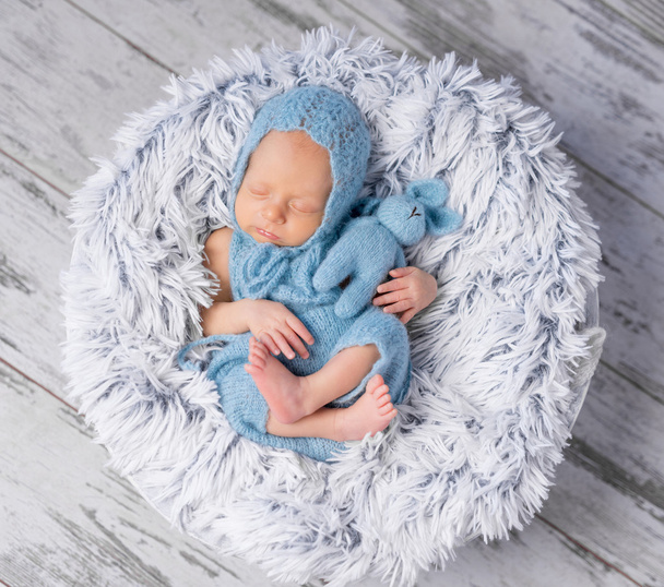 infant in hat and jumpsuit sleeping - Fotó, kép
