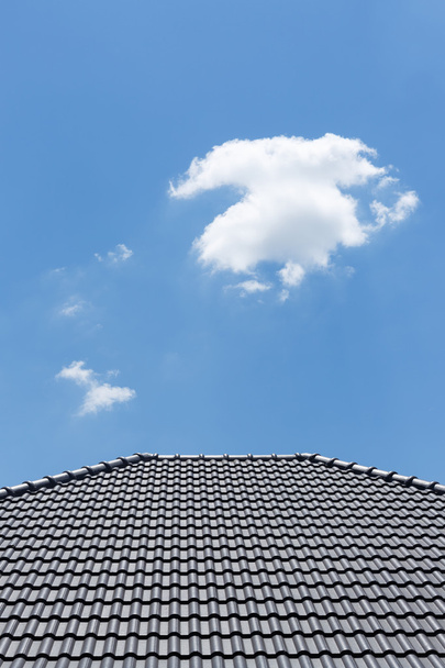 zwarte pannendak op huis met helder blauwe hemel en cloud pagina - Foto, afbeelding