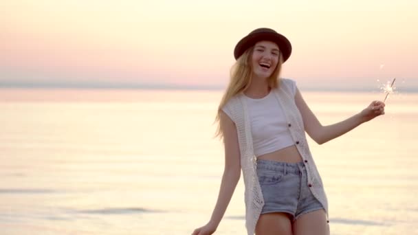 Nastoletnich piękne dziewczyny z ognie na plaży o zachodzie słońca - Materiał filmowy, wideo