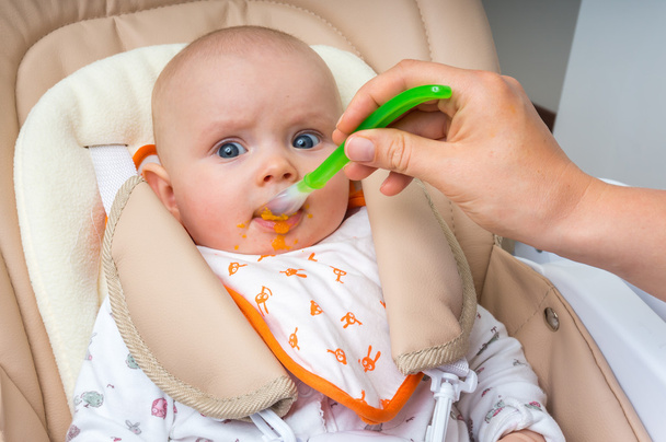 Madre Nutrire la sua bambina con un cucchiaio
 - Foto, immagini