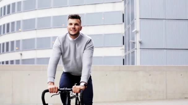 young man riding bicycle on city street - Filmagem, Vídeo