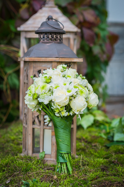  the wedding bouquet for the bride made of white roses and green chrysanthemum  Vintage wooden lantern and moss on the background - Photo, Image
