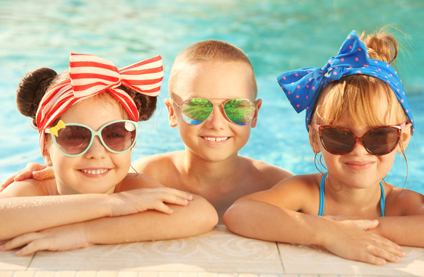 Little kids in swimming pool on sunny day - Foto, Imagen