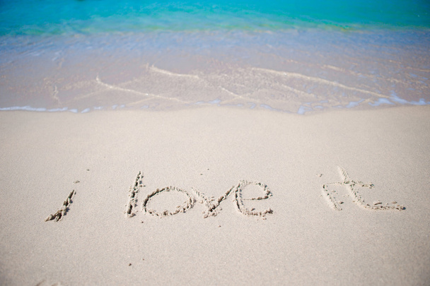 Word i love it handwritten on sandy beach with soft ocean wave on background - Zdjęcie, obraz