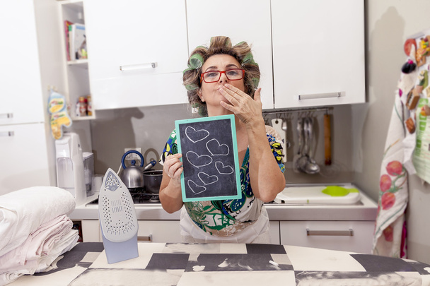 hospodyňka zralé ženy s natáčky ukazuje deska se srdíčky - Fotografie, Obrázek
