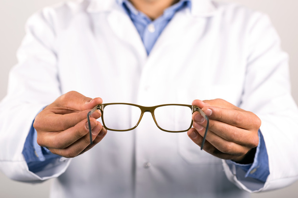 検眼医は患者に新しいメガネを与える - 写真・画像