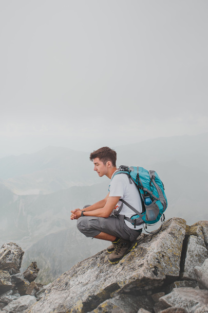 Boy sitting on a mountain peak - Photo, Image