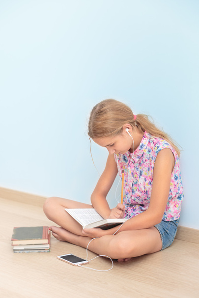 Schoolgirl reading a book in classroom - Foto, immagini