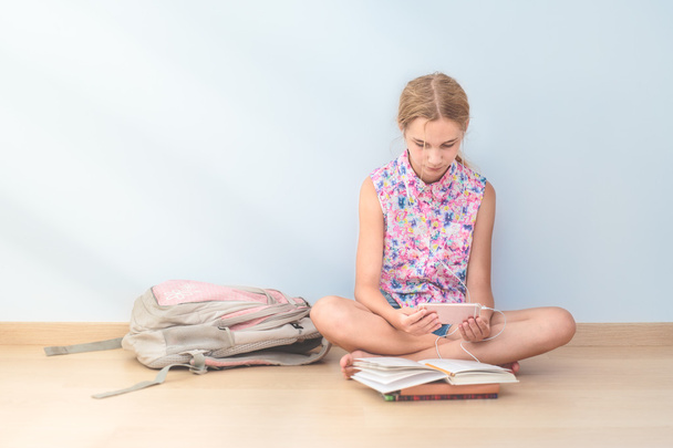 Schoolgirl reading a book in classroom - Foto, Imagen