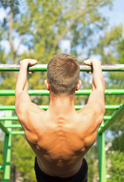 Muscular Young Man During His Workout in the Park. Exercício de rua
. - Foto, Imagem