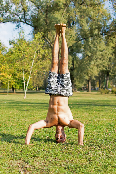 Young Athlete Standing on Head in in the Park. Street Workout. - Foto, Imagem